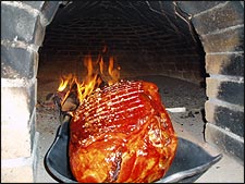 Der Beinschinken wird langsam im Offenen Feuer gebacken. 